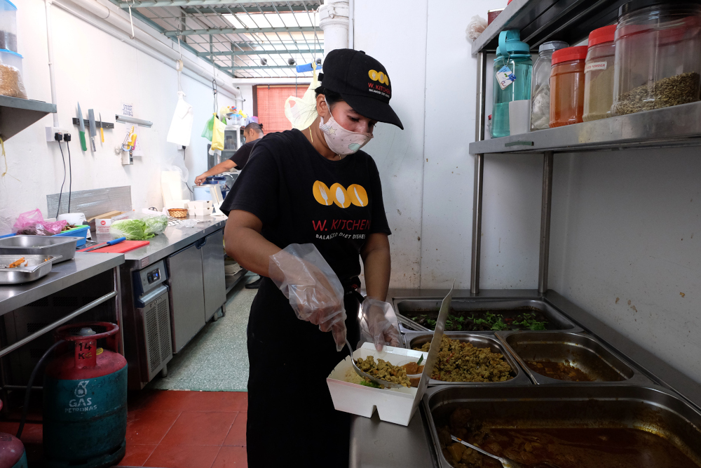 A kitchen staff preparing the lunch box in the kitchen. u00e2u20acu201d Picture by Steven Ooi KE