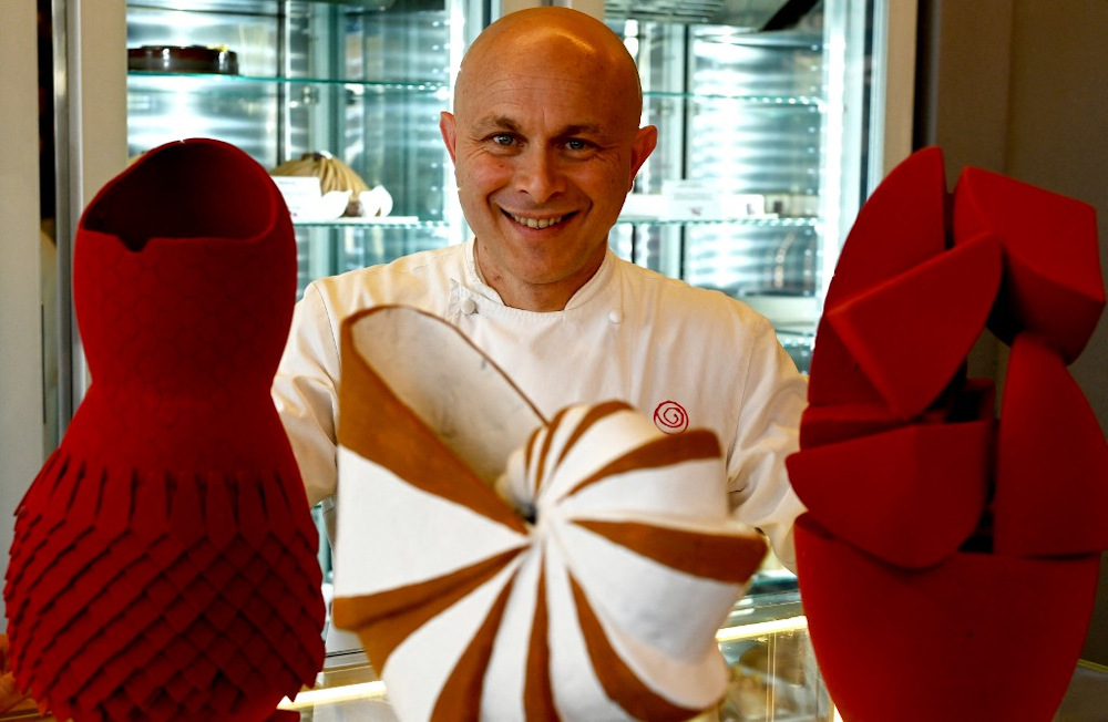 Pastry chef Walter Musco poses with Easter chocolate eggs sculpted to pay a tribute to (from left) fashion designer Azzedine Alaia, mathematician Leonardo Fibonacci and a Cubistic egg, in his pastry shop Pasticceria Bompiani March 30, 2021. u00e2u20acu201d AFP pic