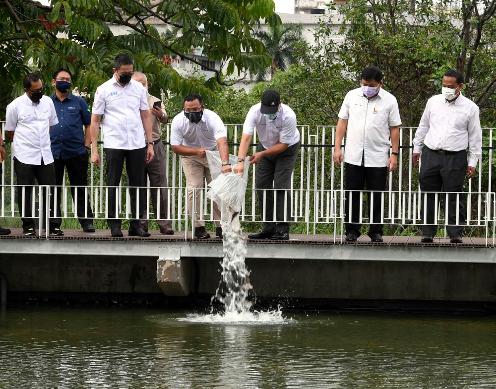 Selangor Mentri Besar Datuk Seri Amirudin Shari releasing fish into the river during his visit to the Selangor Maritime Gateway project at Taman Awam Pengkalan Batu in Klang, March 23, 2021. u00e2u20acu201d Bernama pic