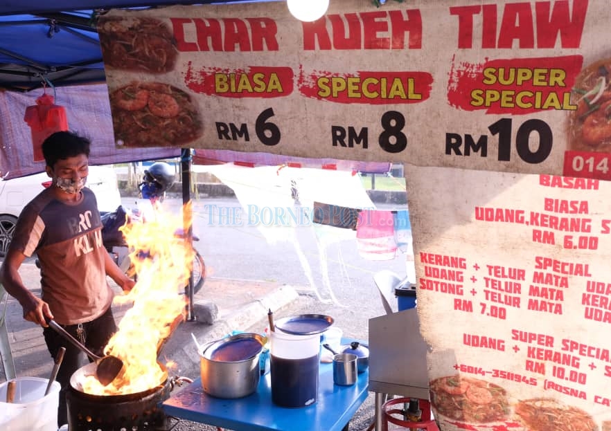 A food operator fries up an order of u00e2u20acu02dckuetiauu00e2u20acu2122 at Jalan Demak. u00e2u20acu2022 Picture by Rais Sanusi/Borneo Post