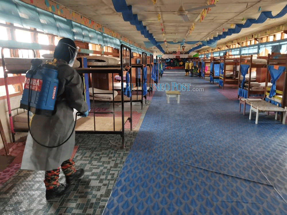 A firefighter conducts sanitisation works on a hostel block at SMK Bakong in Beluru. u00e2u20acu201d Borneo Post Online picn