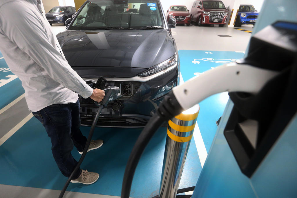 An electric vehicle owner charging his car at a charging station located in a carpark on Feb 25, 2021. u00e2u20acu201d TODAY pic