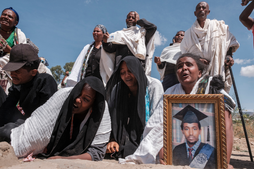 People react as they stand next to a mass grave containing the bodies of 81 victims of Eritrean and Ethiopian forces, killed during violence of the previous months, in the city of Wukro, north of Mekele, February 28, 2021. u00e2u20acu201d AFP pic 