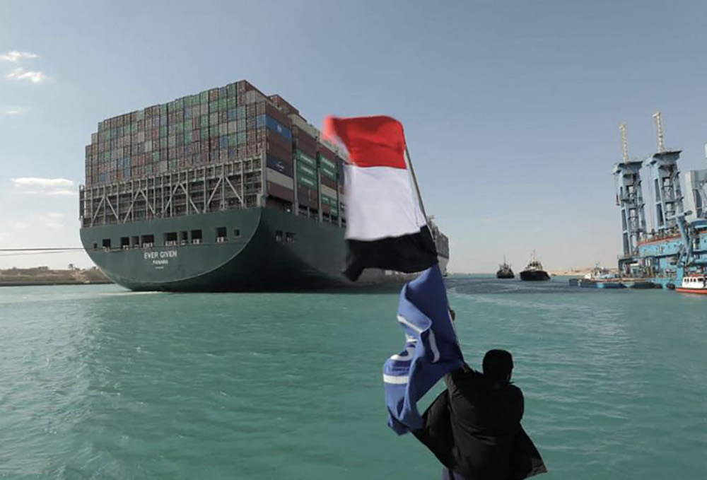 A man waving the Egyptian flag after Panama-flagged MV u00e2u20acu02dcEver Givenu00e2u20acu2122 container ship was fully dislodged from the banks of the Suez, March 29, 2021. u00e2u20acu201d Suez Canal Authority handout pic via AFPnn