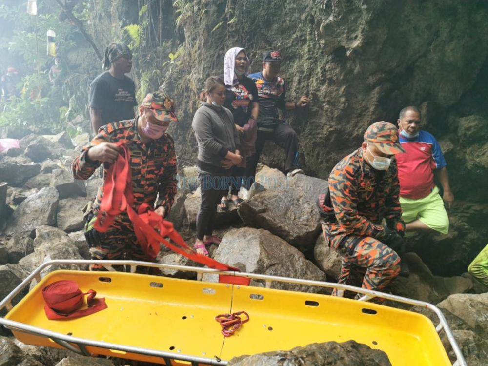 Rescue workers waiting to enter the cave at Gunung Tabai as family members of the victim look on. u00e2u20acu201d Borneo Post Online picnn
