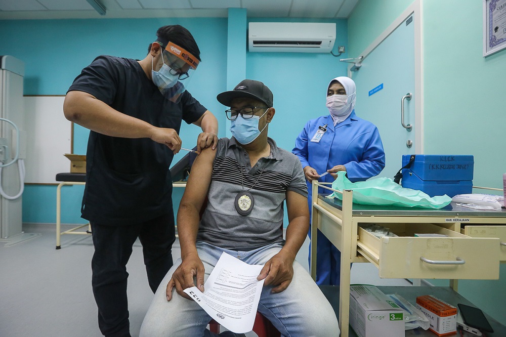 A health worker receives the Pfizer-BioNTech Covid-19 vaccine at the Klinik Kesihatan in Kelana Jaya March 6, 2021. ― Picture by Yusof Mat Isa