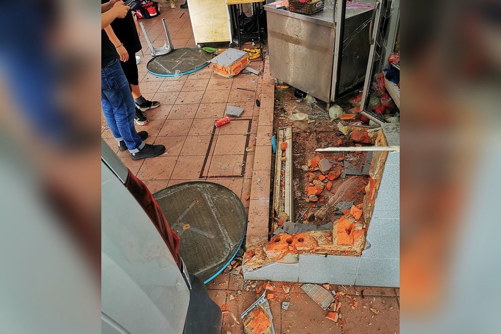 The van reversed more than 5m into the coffee shop, smashing a brick divider and pinning an elderly woman in the fruit stall that she was tending, an eyewitness said. — Picture by Kevin Lim via TODAY