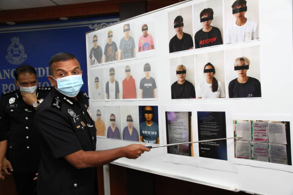 Johor police chief Datuk Ayob Khan Mydin Pitchay points to mugshots of those arrested during Sundayu00e2u20acu2122s raids. u00e2u20acu201d Picture by Ben Tan