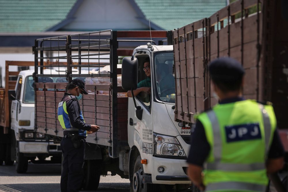Road Transport Department personnel conduct checks on heavy vehicles during Ops Obstacle at the Bukit Raja Toll Plaza March 10, 2021. u00e2u20acu201d Picture by Yusof Mat Isa