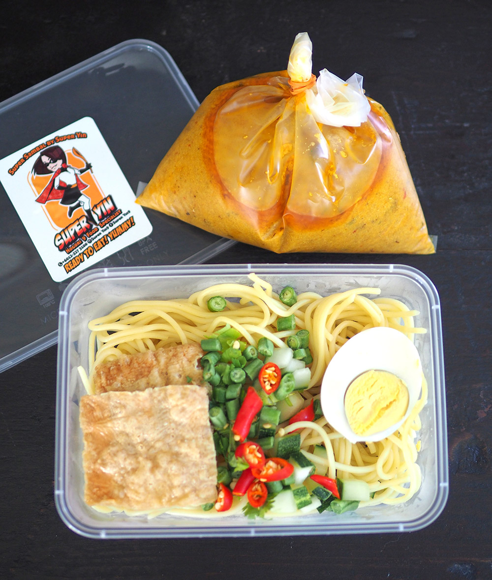 Your food is packed in a plastic box with the laksa broth in a plastic bag.
