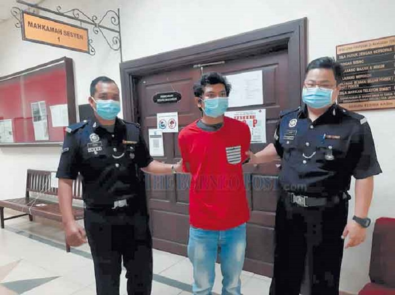 The accused is escorted out of the Sessions Court in Kuching March 5, 2021. u00e2u20acu201d Borneo Post Online pic