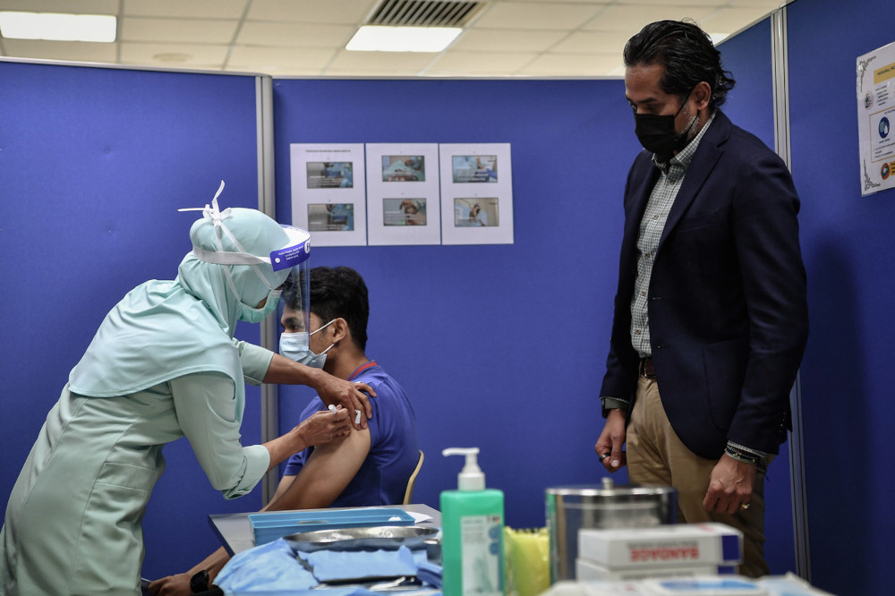 Khairy Jamaluddin watches a nurse administer the Covid-19 vaccine at the Universiti Malaya Medical Centre (PPUM) vaccination centre in Kuala Lumpur, March 9, 2021. u00e2u20acu201d Bernama pic 