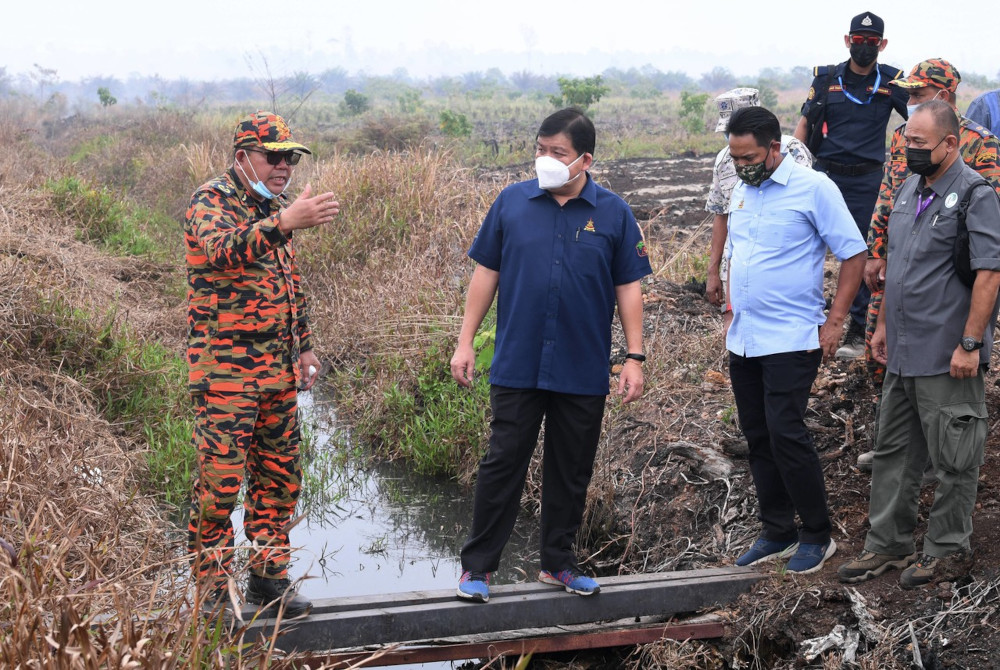 Selangor Tourism, Environment, Green Technology and Orang Asli Affairs Committee chairman Hee Loy Sian (second, left) monitoring the firefighting work in Kuala Langat Selatan Forest Reserve in Tanjung Sepat, March 2, 2021. u00e2u20acu201d Bernama picnn