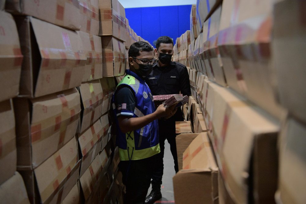 Police conduct checks on the smuggled cigarettes in Pontian, March 10, 2021. u00e2u20acu201d Bernama pic 