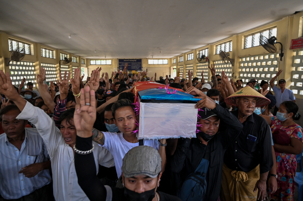 Mourners hold up the three finger salute as they carry the coffin during the funeral of teenage protester Aung Kaung Htet in Yangon March 21, 2021, a day after he was killed by security forces at a demonstration against the military coup. u00e2u20acu201d AFP picnn