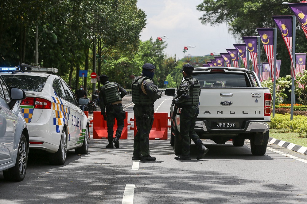 Police personnel stand guard at the road leading to Parliament in Kuala Lumpur March 27, 2021. 