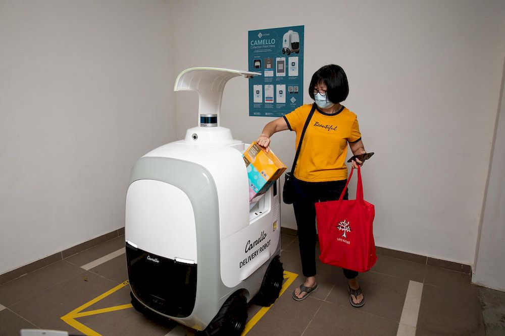 Christine Chong, a resident in Punggol Drive, collecting her groceries at the delivery point for the Camello robot, located at the void deck of the housing block. u00e2u20acu201d TODAY pic