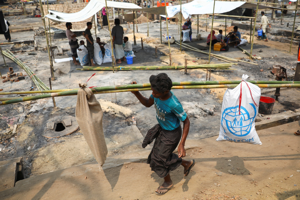 A Rohingya refugee carries relief supplies after a massive fire broke out two days ago in Coxu00e2u20acu2122s Bazar March 24, 2021. u00e2u20acu201d Reuters pic