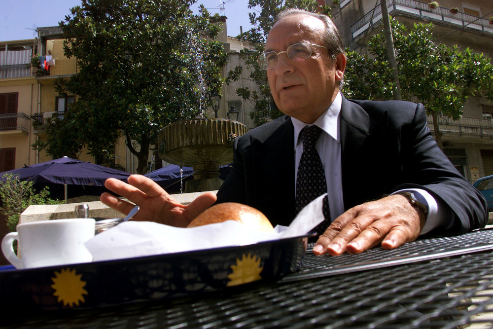 Corleoneu00e2u20acu2122s mayor Nicolo Nicolosi gestures as he sits in a bar in the Sicilian villageu00e2u20acu2122s central square July 23, 2002. u00e2u20acu201d Reuters pic