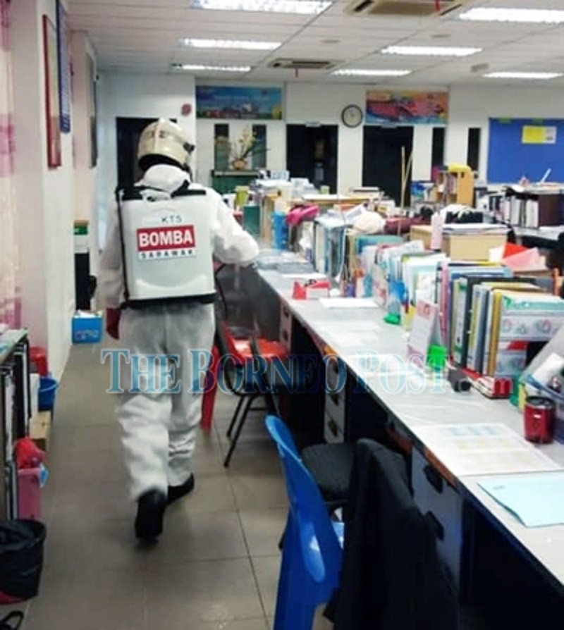 A fireman sanitises the staff room at SJK Methodist. u00e2u20acu2022 Borneo Post pic