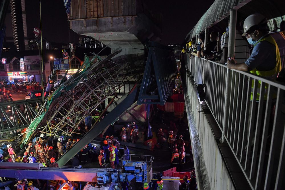 Fire Department personnel remove debris at the collapsed part of the flyover along the Sungai Besiu00e2u20acu201cUlu Klang Elevated Expressway in Kuala Lumpur March 3, 2021. u00e2u20acu201d Bernama pic