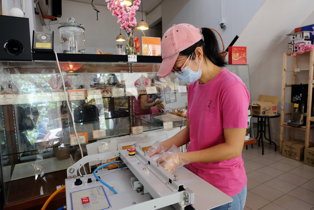 Yin sealing up their Mixed fruit & nut packaging. — Picture by Steven Ooi KE