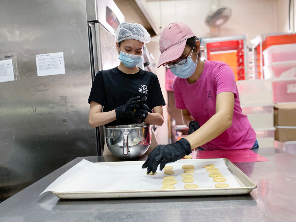 Yin preparing the cookies in their kitchen. — Picture by Steven Ooi KE