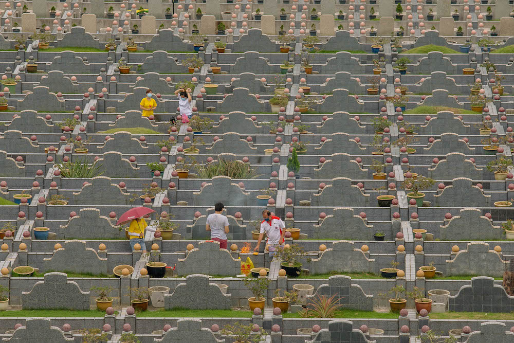 Chinese families visit the graves of their relatives during the Qing Ming festival to clean tombstones and burn offerings in Klang April 4, 2021. u00e2u20acu201d Picture by Firdaus Latif