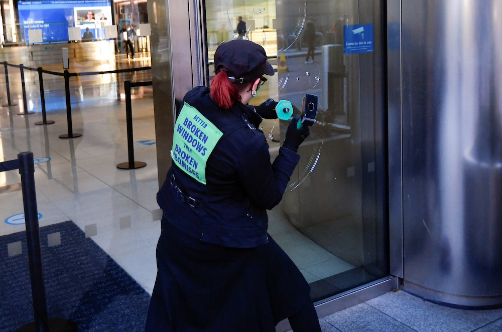 An activist from the Extinction Rebellion, a global environmental movement, damages a window during a direct action at Barclays offices in Canary Wharf, London April 7, 2021. u00e2u20acu201d Reuters pic