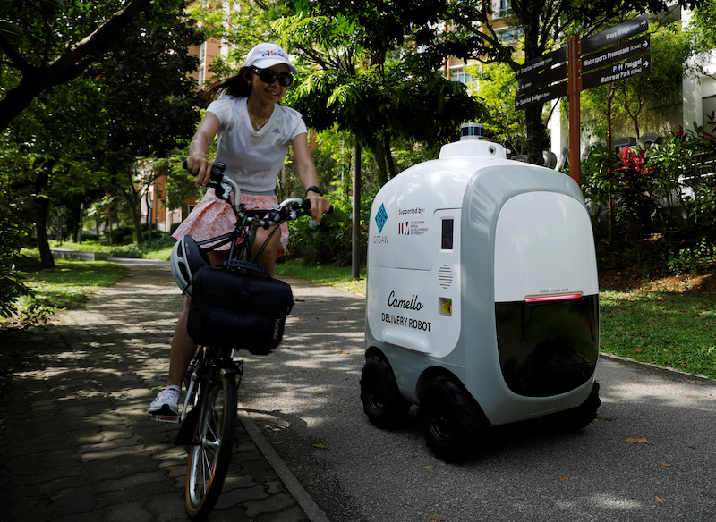 A cyclist passes as Carmello, an autonomous grocery delivery robot, makes its way during a delivery in Singapore April 6, 2021. u00e2u20acu201d Reuters pic