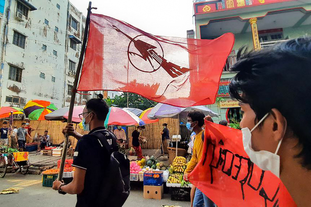 This photo taken and received courtesy of an anonymous source via Facebook on April 12, 2021 shows a protester holding the Yangon Students Union flag during a demonstration against the military coup in Yangon. u00e2u20acu201d Picture via AFP