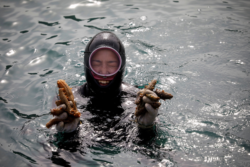 Woo Jung-min, 35, a haenyeo, also known as a u00e2u20acu02dcsea womanu00e2u20acu2122, poses for a photograph with sea cucumbers that she harvested in the sea off Geoje, South Korea, March 31, 2021. u00e2u20acu201d Reuters pic