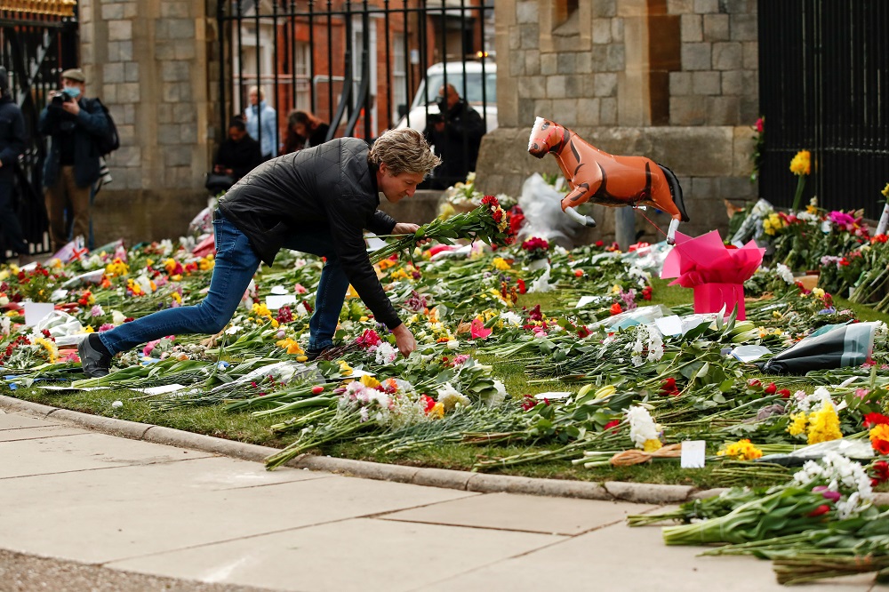 A person leaves flowers outside Windsor Castle after Britain’s Prince Philip, husband of Queen Elizabeth, died at the age of 99, in Windsor, near London April 9, 2021. — Reuters pic