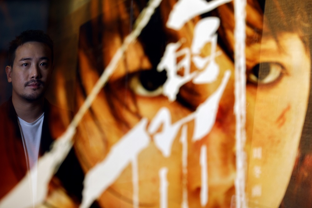 Derek Tsang, director of u00e2u20acu02dcBetter Daysu00e2u20acu2122, is seen on a reflection of a poster of leading actress of the film Zhou Dongyu, after interview with Reuters in Hong Kong April 9, 2021. u00e2u20acu201d Reuters pic