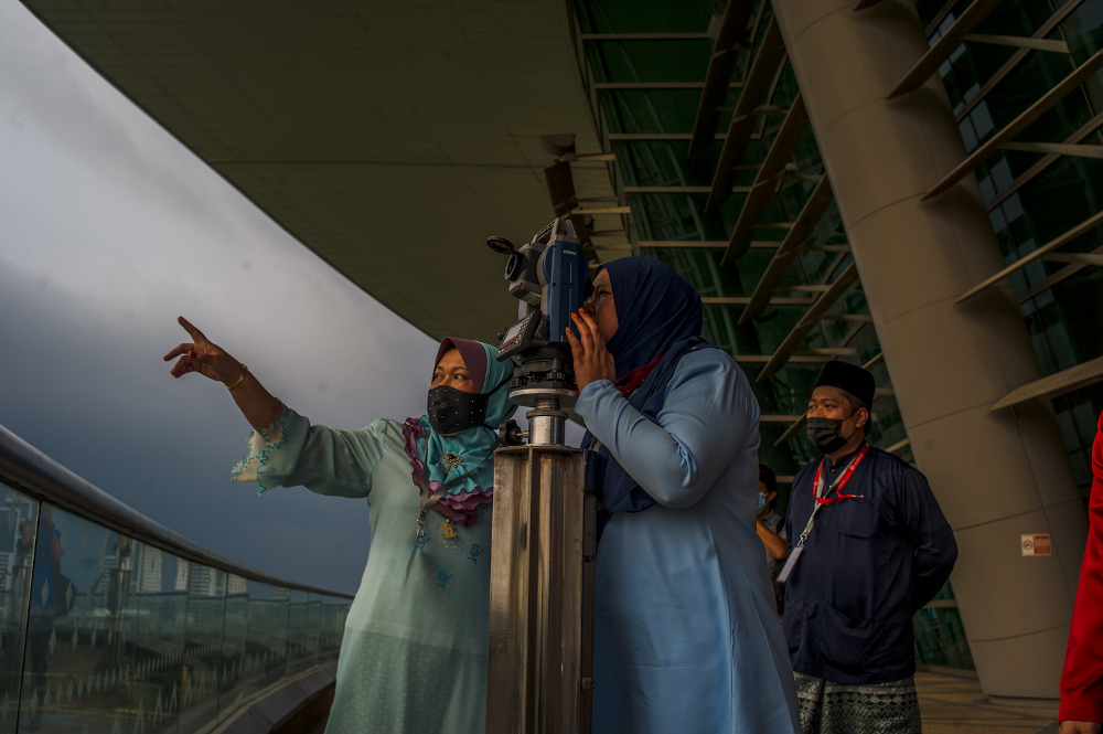 Officers from the Federal Territories Mufti Office look through a telescope to perform u00e2u20acu02dcrukyahu00e2u20acu2122, also known as the sighting of the new moon for Ramadan, at the Putrajaya International Convention Centre April 12, 2021. u00e2u20acu201d Picture by Shafwan Zaidon 