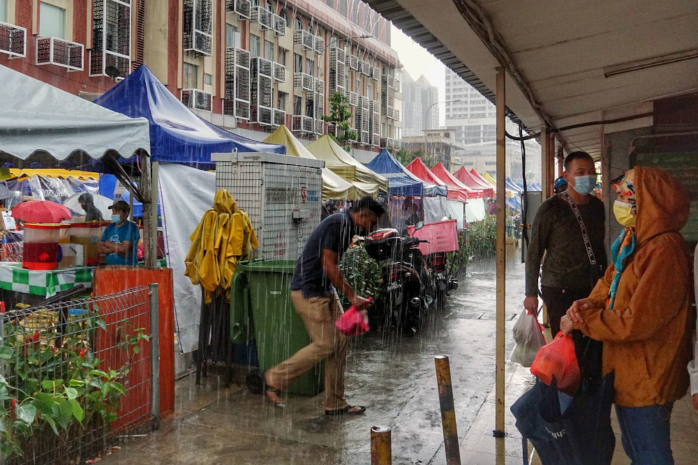 Pedestrians walking on the sidewalk while holding umbrellas in Kampung Baru, Kuala Lumpur Aptil 17, 2021. u00e2u20acu201d Picture by Ahmad Zamzahuri