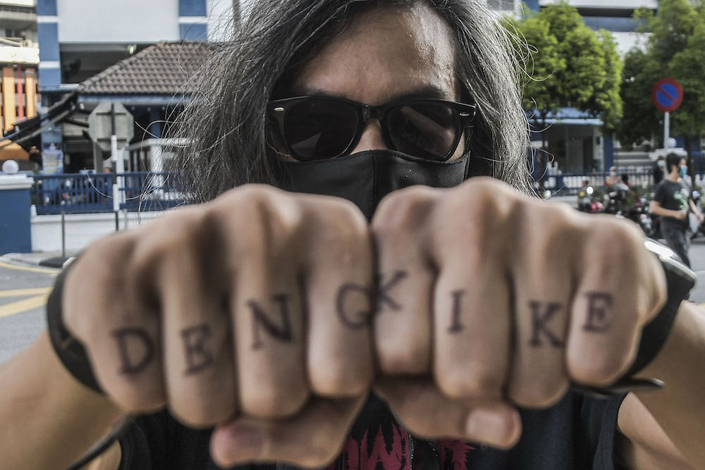 Graphic designer Mohd Fahmi Reza Mohd Zarin (centre) is seen outside the Dang Wangi district police station after his release from his overnight arrest and one-day remand April 24, 2021. ― Picture by Hari Anggara