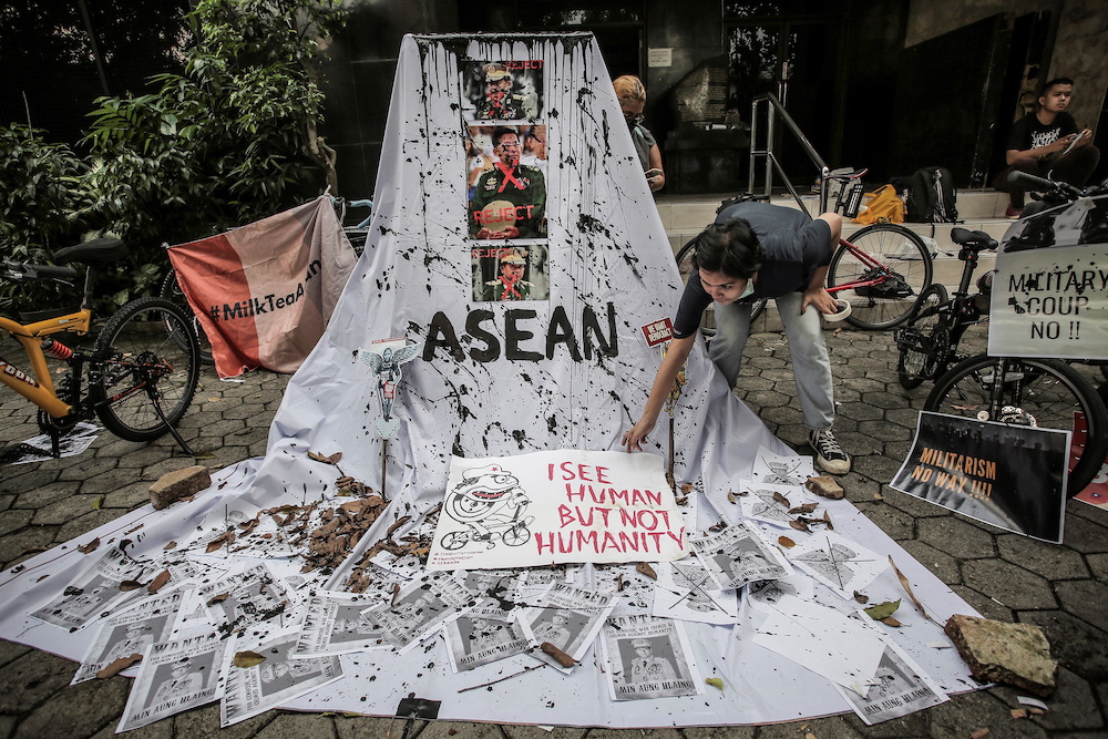 A woman prepares a placard out of crossed out portraits of Myanmar's junta chief Senior General Min Aung Hlaing during protest against the military coup in Myanmar, in Jakarta, Indonesia, April 24, 2021. u00e2u20acu201d Antara Foto/Dhemas Reviyanto via Reuters picnn