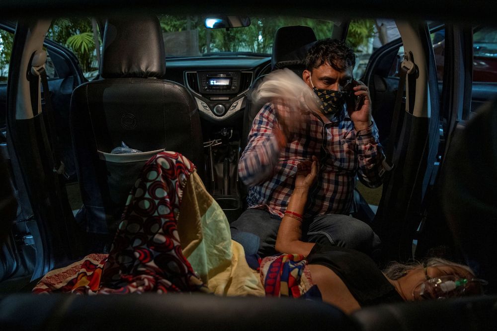 Manoj Kumar sits next to his mother, Vidhya Devi, as she receives oxygen support for free inside her car at a Gurudwara (Sikh temple), amidst the spread of the coronavirus disease (Covid-19), in Ghaziabad, India, April 24, 2021. u00e2u20acu201d Reuters pic