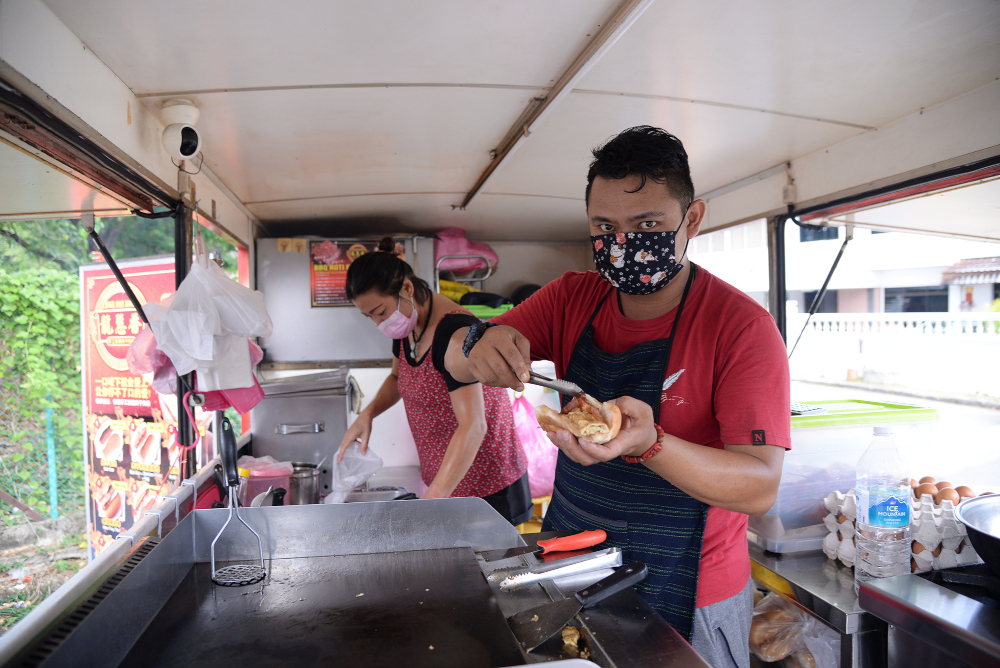 Tan Boon prepares one of the orders for a customer at the food truck. 