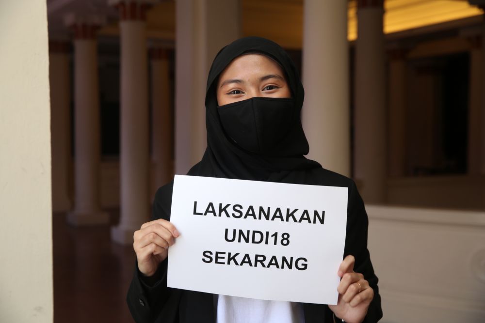 Elisa Shafiqah holds up a sign protesting the delay of Undi18 during a press conference at the Kuala Lumpur and Selangor Chinese Assembly Hall April 2, 2021. — Picture by Choo Choy May