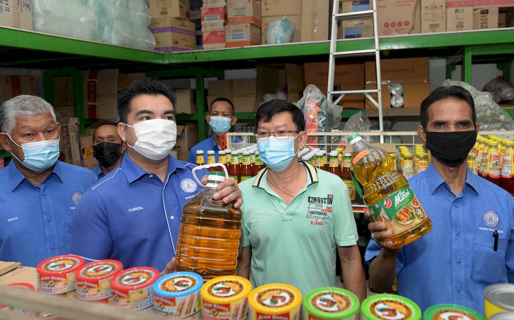 Secretary of the Kedah Consumers Association, Mohamad Yusrizal Yusoff (second left) with Kedah Consumer Monitoring Chairman Mohd Fauzi Sharip (right) inspecting cooking oil on sale at a mini market at Jalan Kilang Ais, Alor Star, April 24, 2021. u00e2u20acu201d Berna