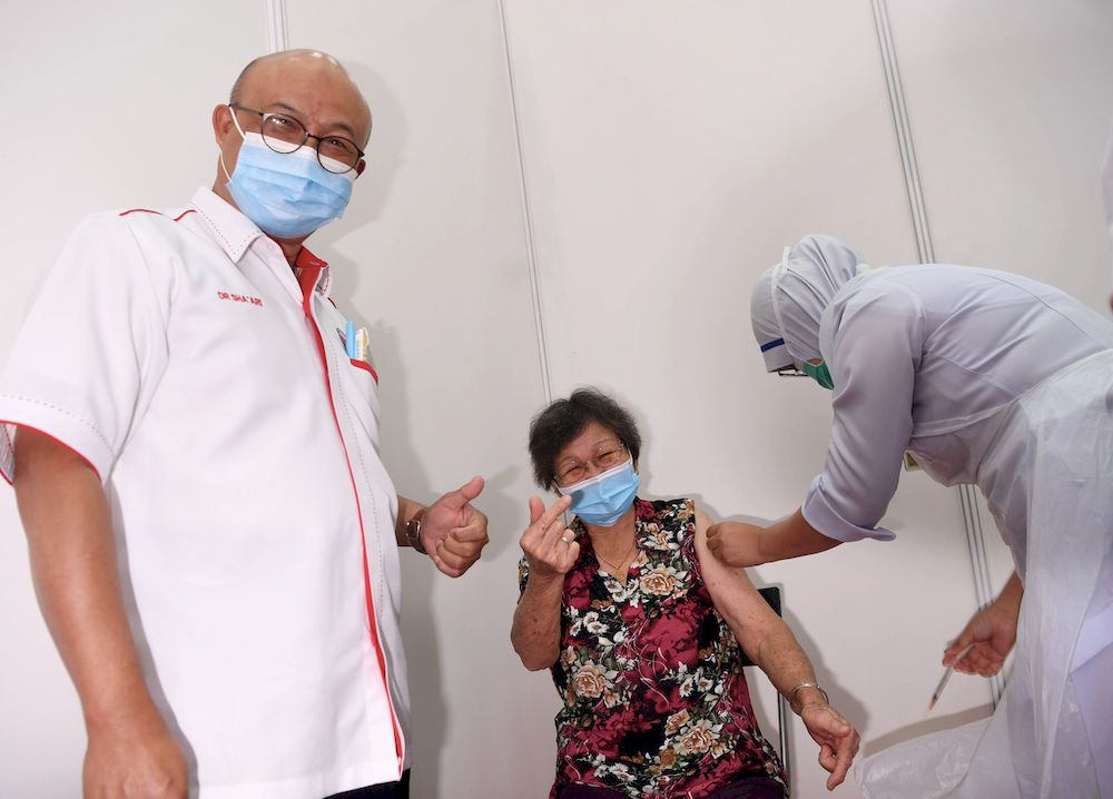 Selangor State Health Director Datuk Dr Shaari Ngadiman (left) with Covid-19 vaccine recipient, Boon Sew Moi, 80, in conjunction with the National Covid-19 Immunisation Program Phase Two during a visit to the Vaccine Center (PPV ) at the Pandamaran Sports