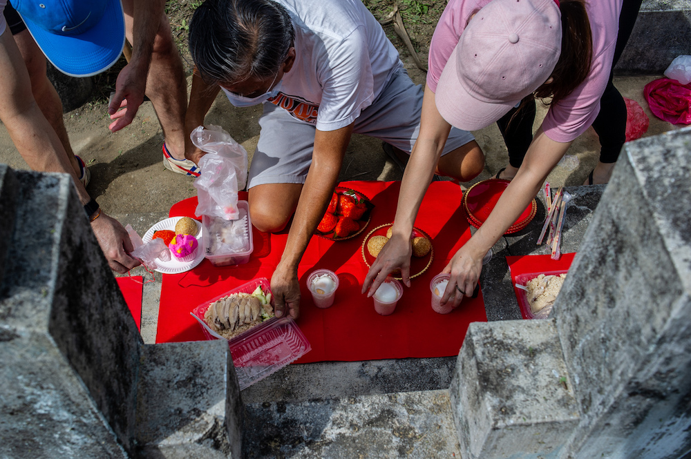 Family members clean and pray at the graves of their ancestors as a sign of respect and to honour their deceased relatives during the Qing Ming festival at the Kwong Tong Chinese Cemetery in Kuala Lumpur April 4, 2021. — Picture by Shafwan Zaidon