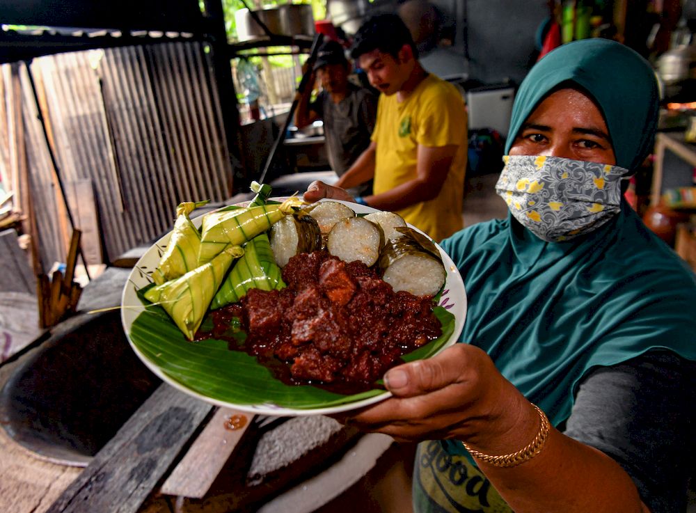 Huda Mat Isa (right) shows a rendang tok dish in Kampung Pasir Putih, Ipoh, April 24, 2021. u00e2u20acu201d Bernama pic