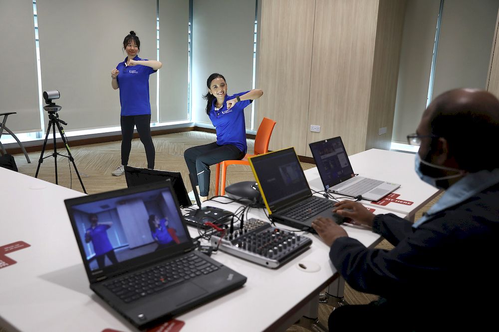 Carina Wong (left) and Nurul Shafiqah (centre) from Tan Tock Seng Hospital conducting a virtual exercise session on April 16, 2021. — TODAY pic