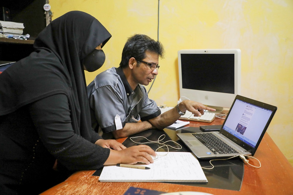 Rohingya refugee and activist Zafar Ahmad Abdul Ghani and his wife look at a computer screen displaying the threats and hate speech they received, at their home in Kuala Lumpur March 19, 2021. u00e2u20acu2022 Reuters pic