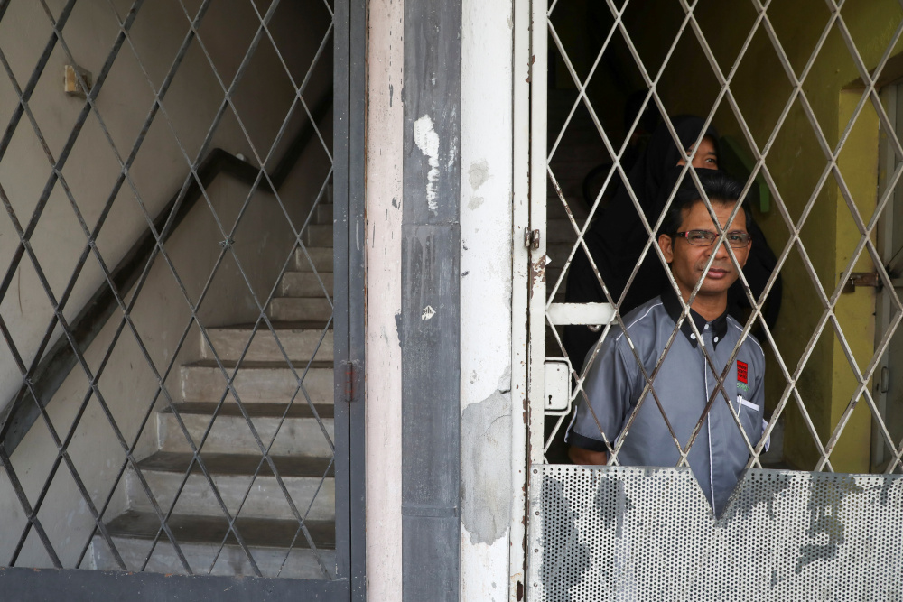 Rohingya refugee and activist Zafar Ahmad Abdul Ghani and his wife look out from their home in Kuala Lumpur, Malaysia March 19, 2021. Picture taken March 19, 2021. u00e2u20acu201d Reuters picnn
