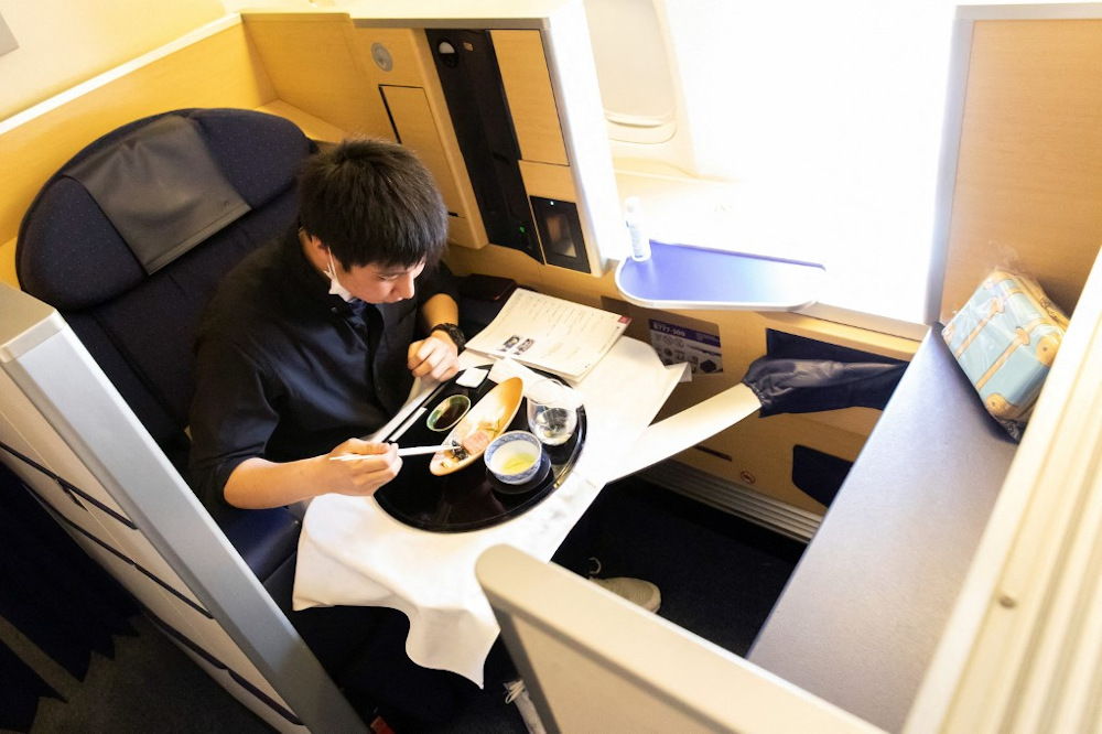 In this handout photograph taken on March 31, 2021 by All Nippon Airways (ANA), a customer has his meal on a parked plane at Haneda airport in Tokyo. u00e2u20acu201d AFP pic