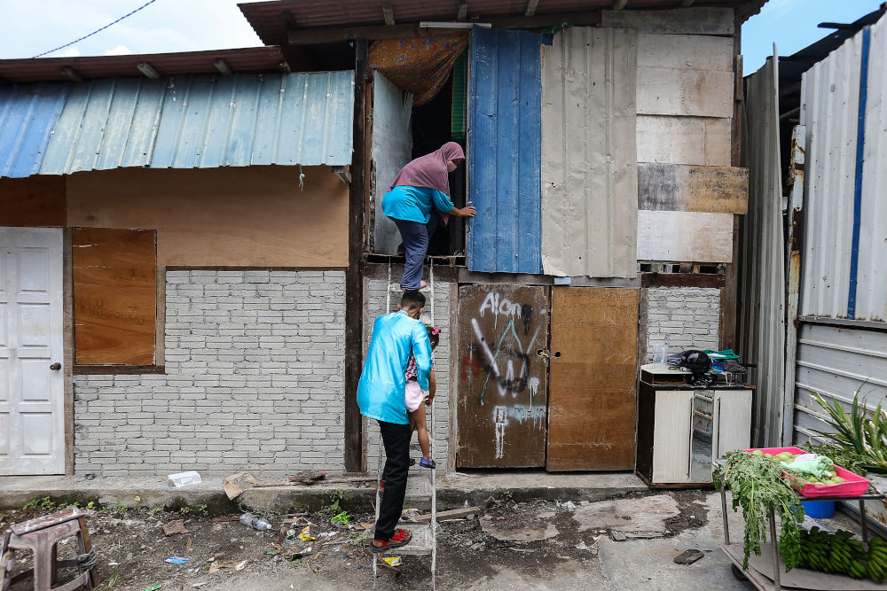 Effandy Abd Rahim and his wife Salbilla Supriyadi are temporarily living in the neighbour’s storage space, a makeshift shack one storey up and is only accessible through a rickety ladder. — Picture by Sayuti Zainudin